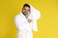 Young man in bathrobe drying hair with towel on background Royalty Free Stock Photo