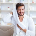 The young man in a bathrobe after shower drying hair with a towe Royalty Free Stock Photo
