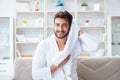 The young man in a bathrobe after shower drying hair with a towel Royalty Free Stock Photo