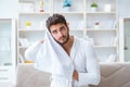 The young man in a bathrobe after shower drying hair with a towel Royalty Free Stock Photo