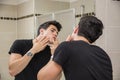 Young Man in Bathroom Squeezing a Spot