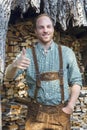 Young man in bavarian lederhosen with thumbs up