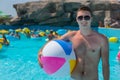 Young Man with Beach Ball Standing in Pool Royalty Free Stock Photo