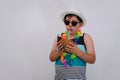 A young man on the beach dressed in a blue sleeveless shirt drinking a coconut. Boy on a white isolated background with beach Royalty Free Stock Photo