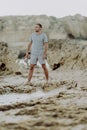 Young man on the beach, man walking on the rocky beach coastline