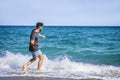 Young Man on Beach Skipping Stones on Sea Royalty Free Stock Photo