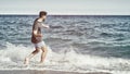 Young Man on Beach Skipping Stones on Sea Royalty Free Stock Photo