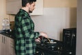 Young man with beard cooking dinner at the kitchen. Royalty Free Stock Photo