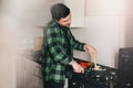 Young man with beard cooking dinner and using his smart phone at the kitchen. Royalty Free Stock Photo