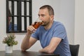 A young man with a beard drinks beer from a glass in a cafe Royalty Free Stock Photo