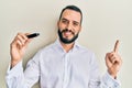 Young man with beard holding removable memory usb smiling happy pointing with hand and finger to the side Royalty Free Stock Photo