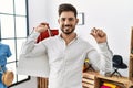 Young man with beard holding shopping bags and bitcoin smiling with a happy and cool smile on face Royalty Free Stock Photo