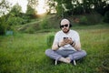 Young man with beard lying on grass and listening music Royalty Free Stock Photo