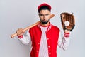 Young man with beard playing baseball holding bat and ball depressed and worry for distress, crying angry and afraid Royalty Free Stock Photo