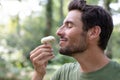 young man with beard smelling mushroom