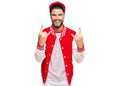 Young man with beard wearing baseball uniform shouting with crazy expression doing rock symbol with hands up