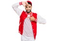 Young man with beard wearing baseball uniform smiling making frame with hands and fingers with happy face