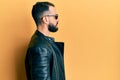 Young man with beard wearing black leather jacket and sunglasses looking to side, relax profile pose with natural face with Royalty Free Stock Photo