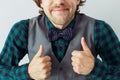 Positive smiling man with beard in a bowtie and green shirt