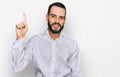Young man with beard wearing business shirt showing and pointing up with finger number one while smiling confident and happy Royalty Free Stock Photo