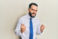 Young man with beard wearing business tie very happy and excited doing winner gesture with arms raised, smiling and screaming for Royalty Free Stock Photo