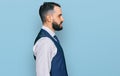 Young man with beard wearing business vest looking to side, relax profile pose with natural face with confident smile Royalty Free Stock Photo