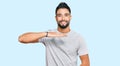 Young man with beard wearing casual grey tshirt gesturing with hands showing big and large size sign, measure symbol Royalty Free Stock Photo