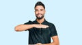 Young man with beard wearing sportswear gesturing with hands showing big and large size sign, measure symbol Royalty Free Stock Photo