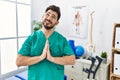 Young man with beard working at pain recovery clinic begging and praying with hands together with hope expression on face very Royalty Free Stock Photo