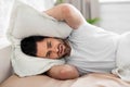 Young man in bed covering head with pillow Royalty Free Stock Photo