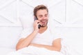 Young man in bed having phone conversation. Phone call. Man with smartphone in bed. Smartphone communication. Millennial Royalty Free Stock Photo