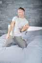 Young man in bed playing air guitar Royalty Free Stock Photo