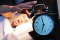 Young man in bed stopping the alarm clock Royalty Free Stock Photo