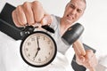 Young man in bed about to hammer his alarm clock Royalty Free Stock Photo