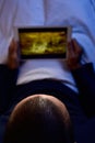 Young man in bed watching a movie or a series in his tablet Royalty Free Stock Photo