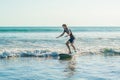 Young man, beginner Surfer learns to surf on a sea foam on the B