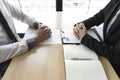 Young men are being interviewed by employers. The employer wears a black suit explaining the job application