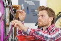 Young man bicycle mechanic repairing bicycles Royalty Free Stock Photo