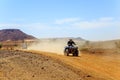 Young man riding quad bike in desert