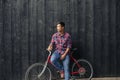 Young man with a bike leaning against a city wall Royalty Free Stock Photo