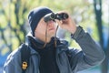 Young man with binoculars bird watching at demi-season natural background Royalty Free Stock Photo