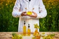 A young man biologist or agronomist examines the quality of rapeseed oil on a rape field. Agribusiness concept Royalty Free Stock Photo