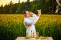 A young man biologist or agronomist examines the quality of rapeseed oil on a rape field. Agribusiness concept Royalty Free Stock Photo