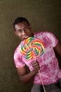 Young Man Bites Into a Giant Lollipop Royalty Free Stock Photo