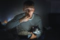 Young man with black cat watching a movie eating popcorn on TV at home. Movie night. Relax,rest watching a horror film or video on Royalty Free Stock Photo