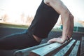 A young man in black clothes is exercising outdoors close up. fitness athlete on the sports field. training with projectiles. warm Royalty Free Stock Photo