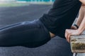 A young man in black clothes is exercising outdoors close up. fitness athlete on the sports field. training with projectiles. warm Royalty Free Stock Photo