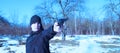 Young man in black clothes shoots with a pistol on nature in winter