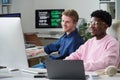 Young Man and Young Black Man Collaborating in Office Workspace Royalty Free Stock Photo