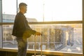 Young man in a black jacket with suitcase waiting for boarding in the airport Royalty Free Stock Photo